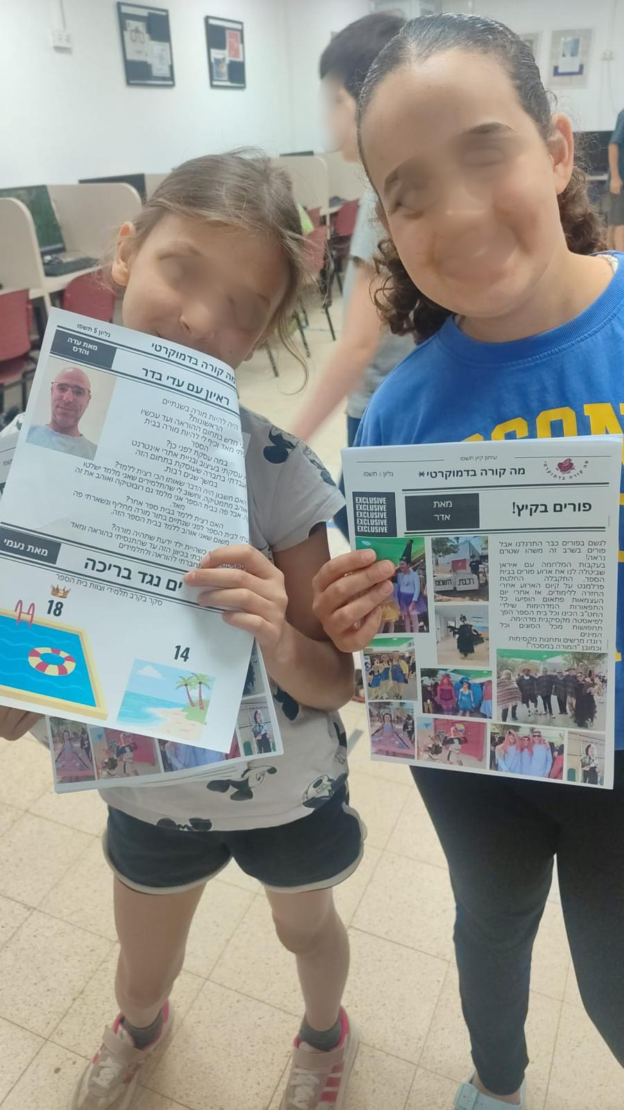 תלמידות מציגות בגאווה את עיתון בית הספר