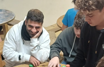תמונה של חונך משחק משחק קופסה עם תלמידים במפגש חונכות
